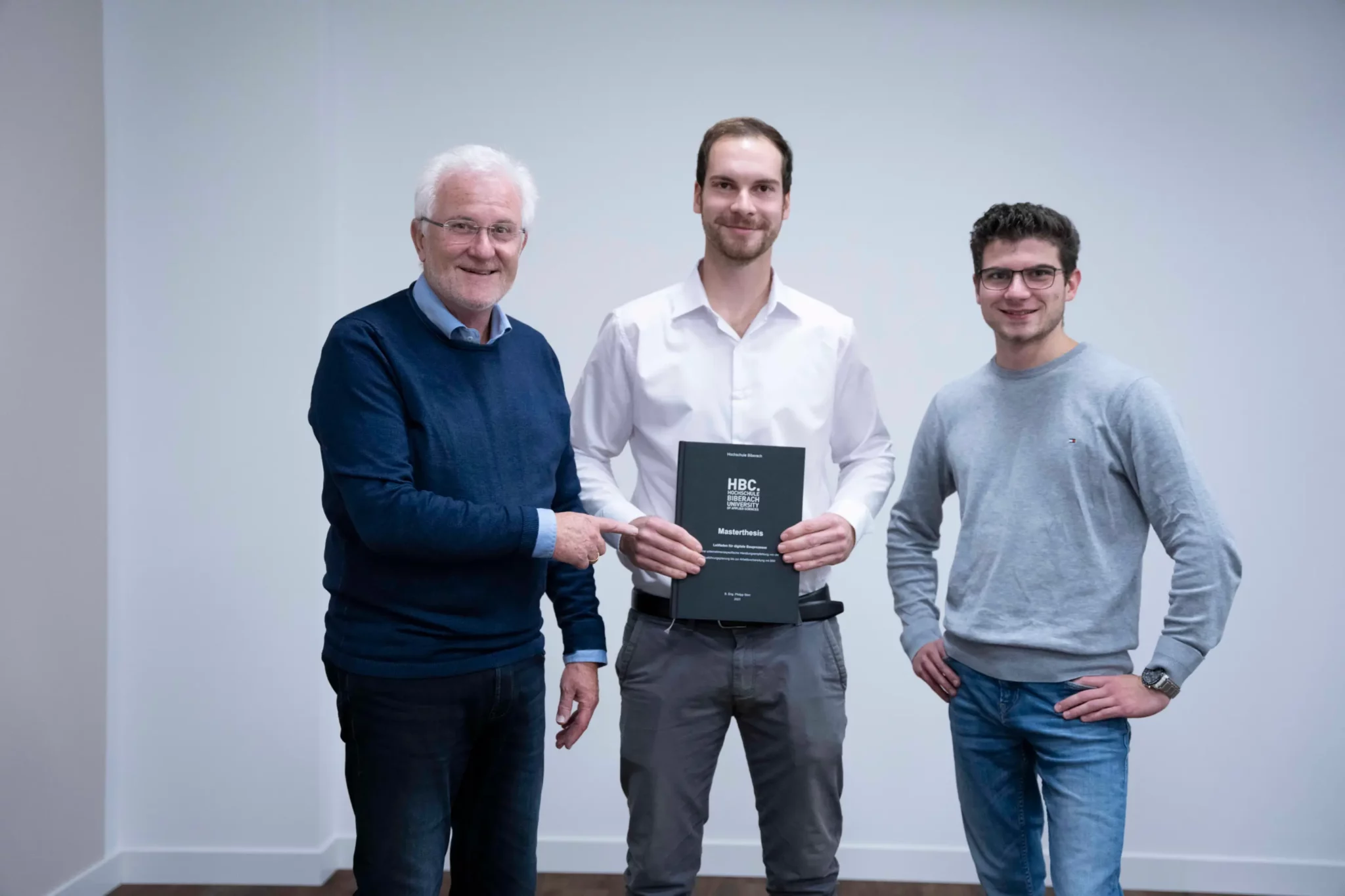 Burkhard Isenmann und Luca Isenmann gratulieren Philipp Storr zum erfolgreich abgeschlossenen Master.