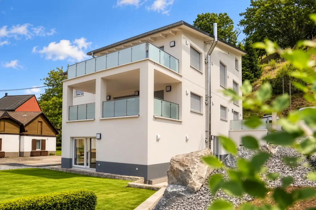 Rückansicht des sanierten Mehrfamilienhauses mit modernen Balkonen