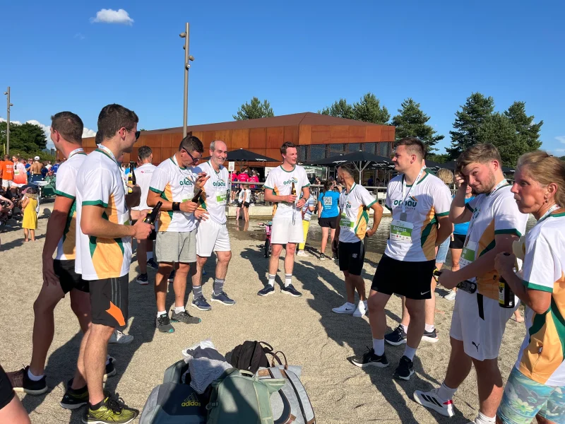 Das orbau-Team steht nach dem Lauf zusammen und genießt Getränke.