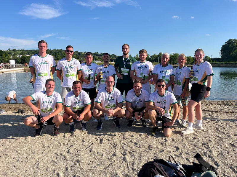 Das orbau-Team posiert nach dem Firmenlauf am Seeufer für ein Gruppenfoto.