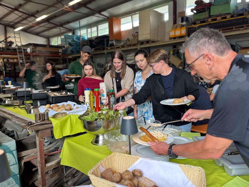 Mitarbeitende bedienen sich am Buffet beim Sommerfest auf dem Bauhof.