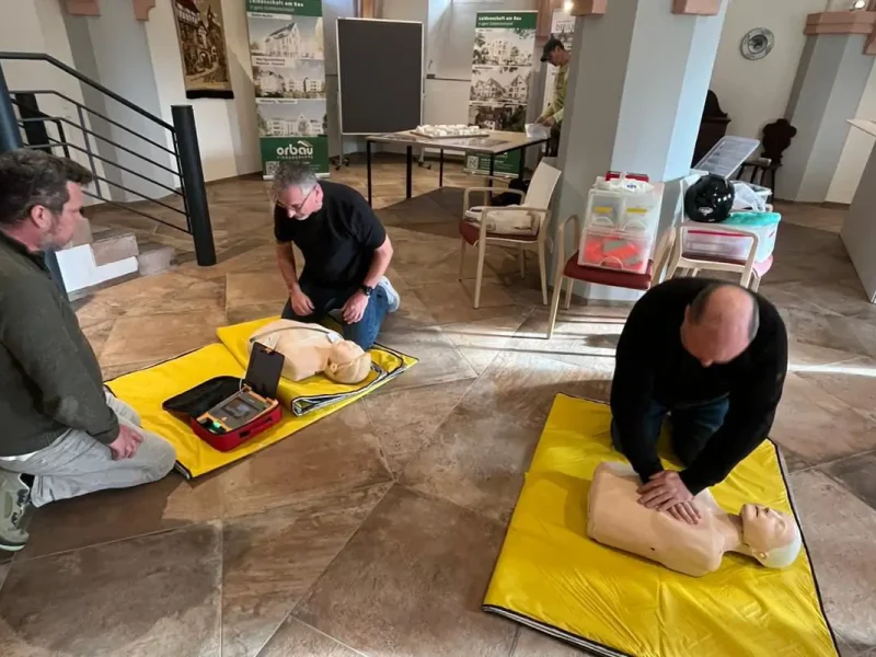 Mehrere Teilnehmer üben Erste-Hilfe-Maßnahmen während der Ersthelfer-Schulung bei orbau.