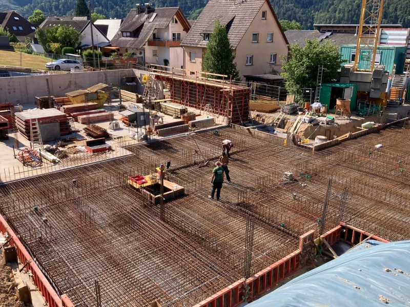 Baustelle des Mehrgenerationenhauses in Fischerbach Anfang Juli mit Bewehrung der Bodenplatte und Baukran.