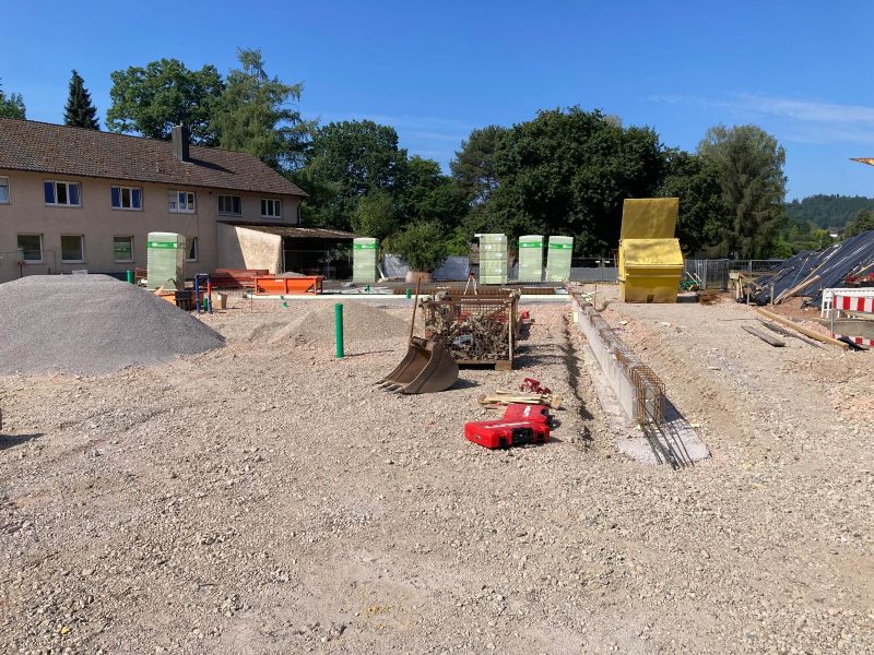 Baustelle mit vorbereiteten Fundamenten und Leitungen