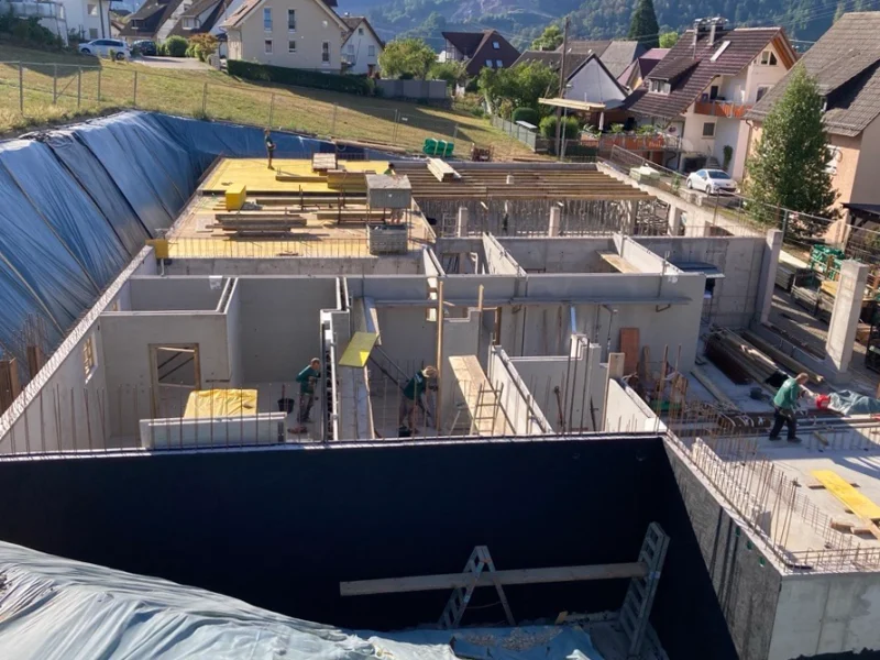 Baufortschritt Ende Juli beim Mehrgenerationenhaus in Fischerbach mit errichtetem Untergeschoss und laufenden Rohbauarbeiten.