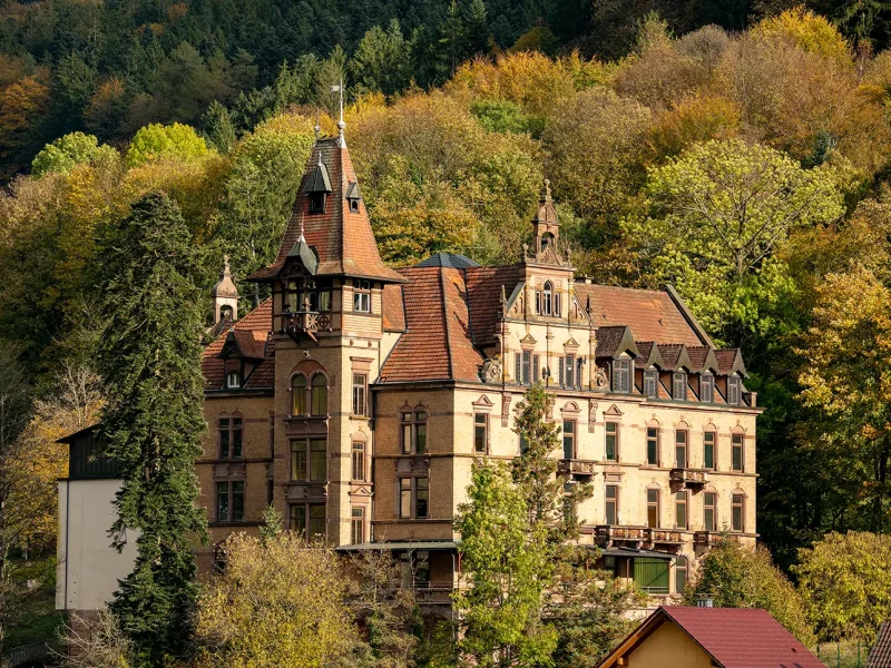 Historisches Schloss Rothschild in Nordrach, umgeben von herbstlichem Wald – Sanierungsprojekt der orbau Firmengruppe.