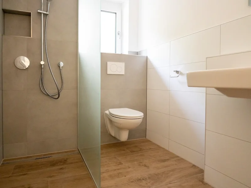 Modernes Badezimmer mit bodengleicher Dusche, WC und Fliesen in Holzoptik