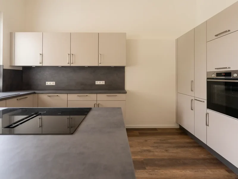 Moderne Einbauküche mit Kochinsel und Holzoptik in sanierter Wohnung