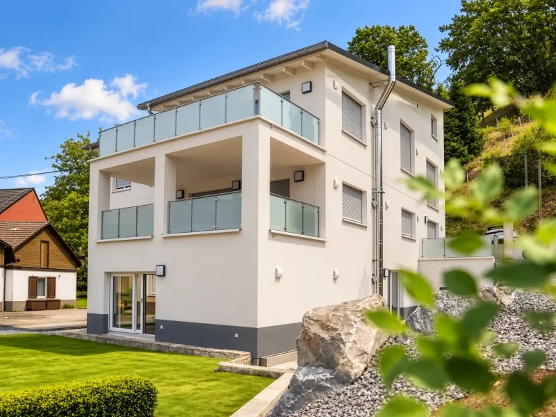 Rückansicht des sanierten Mehrfamilienhauses mit modernen Balkonen