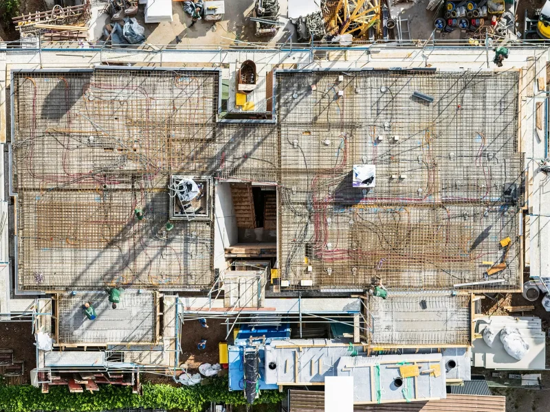 Draufsicht auf die Baustelle in Elgersweier mit sichtbaren Leitungen der Klimadecke – moderne Wohnungen zu kaufen bei Orbau.