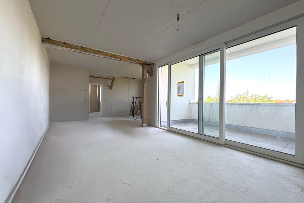 Heller Wohnraum mit großer Fensterfront zur Loggia_website